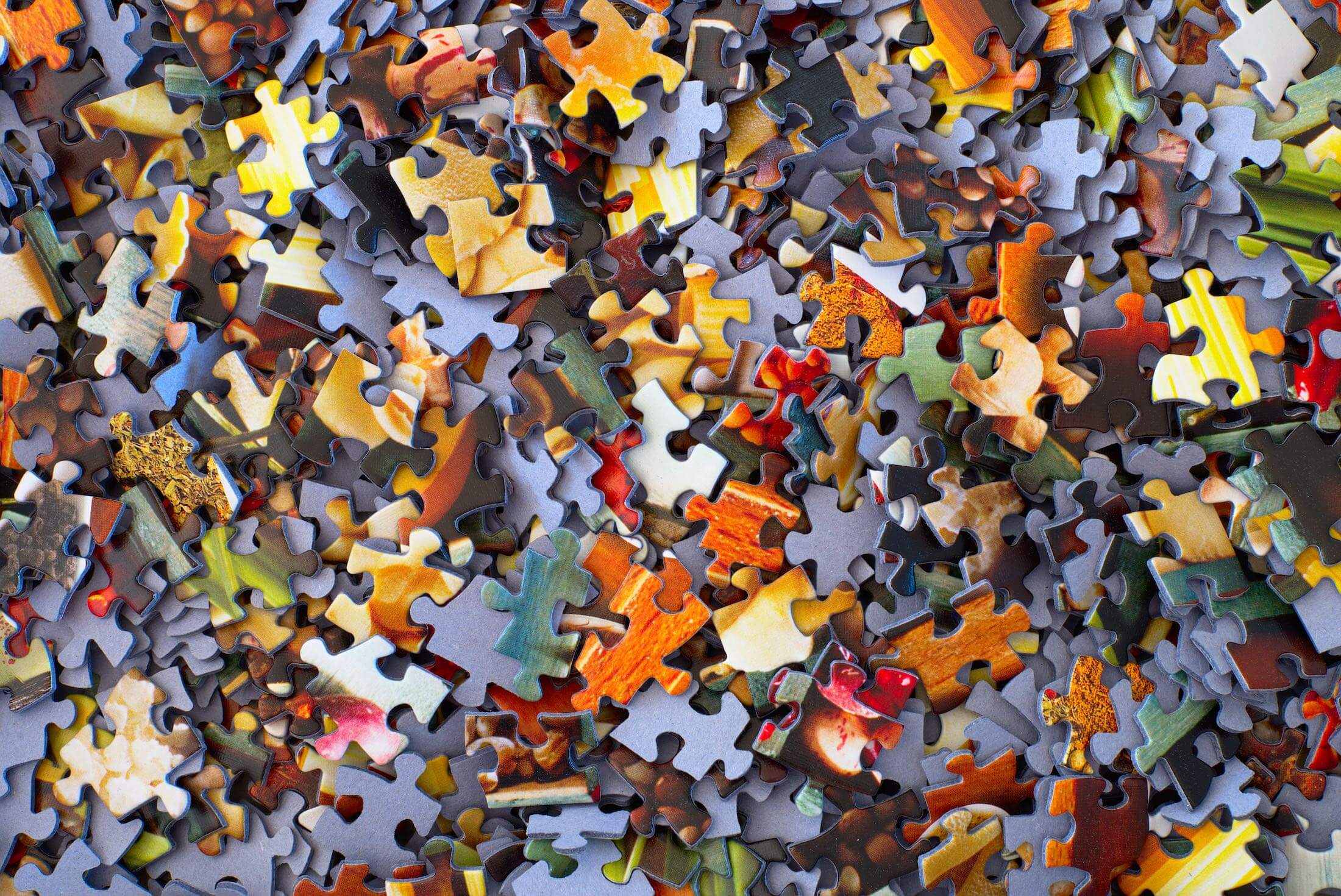 how-to-measure-product-market-fit several orange and grey jigsaw puzzle pieces in a pile